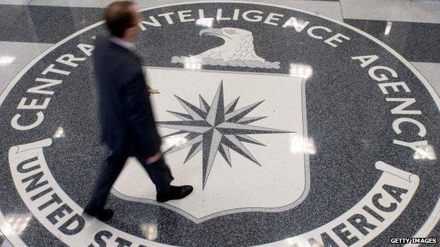 A man crosses the Central Intelligence Agency (CIA) logo in the lobby of CIA Headquarters in Langley, Virginia 14 August 2008