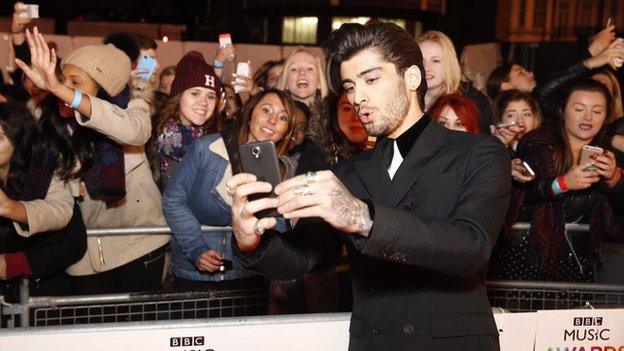 Zayn Malik taking a selfie with fans