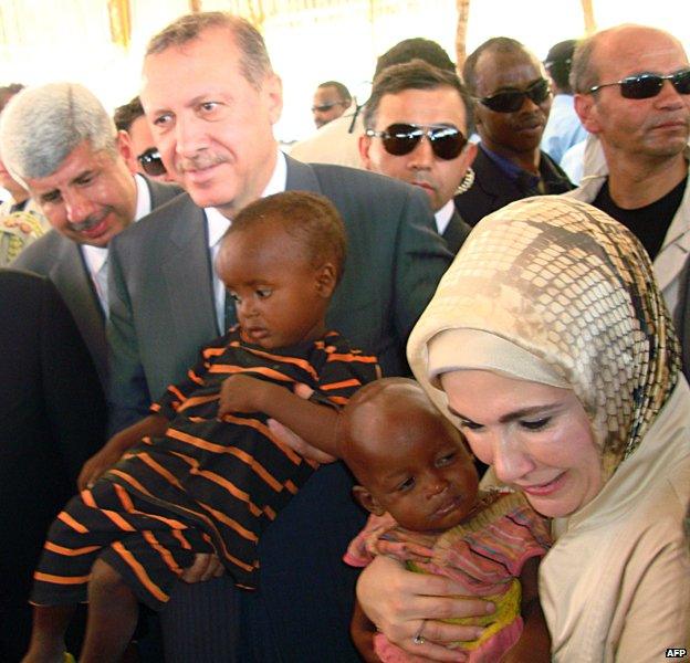 Turkish Prime Minister Recep Tayyip Erdogan and his wife Emine hold children during their visit to a refugee camp in Somalia, August, 2011