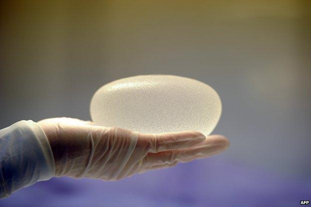 Surgeon holding breast implant