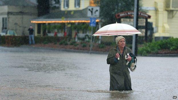 A woman makes her way through floodwaters in Healdsburg, California