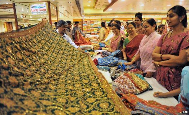 Women look at a display of saris at a wedding collection in Hyderabad