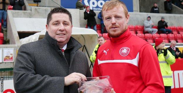 Cliftonville chairman Gerard Lawlor makes a presentation to skipper Gorge McMullan who was making his 500th appearance for the north Belfast club