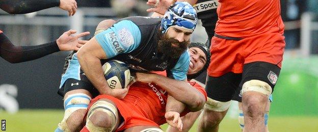 Glasgow captain Josh Strauss is tackeld by Toulouse skipper Thierry Dusautoir