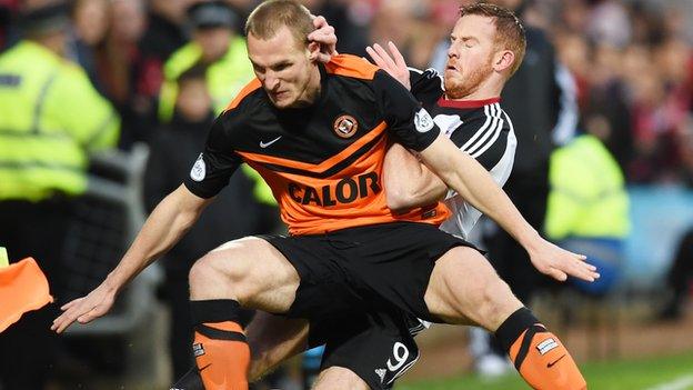 Dundee United's Jaroslaw Fojut shields the ball from Aberdeen's Adam Rooney