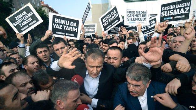 Chaotic scenes as Zaman's editor-in-chief was led through crowds of supporters to a police vehicle.