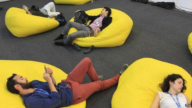 Journalists rest while waiting for the final text of the negotiations.