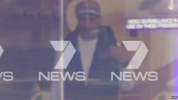 Man wearing a bandana seen through window of Sydney cafe