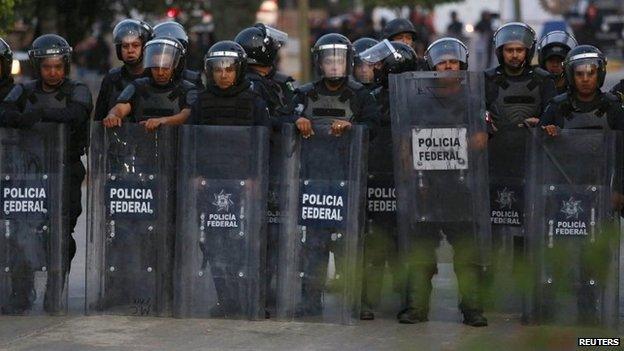 Federal police officers stand guard during clashes in Chilpancingo on 14 December, 2014.