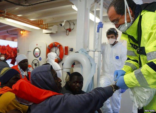 A port doctor tags a migrant at port of Pozzallo, Sicily, 5 Oct 14