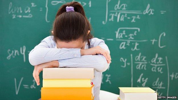 Student with math books in classroom