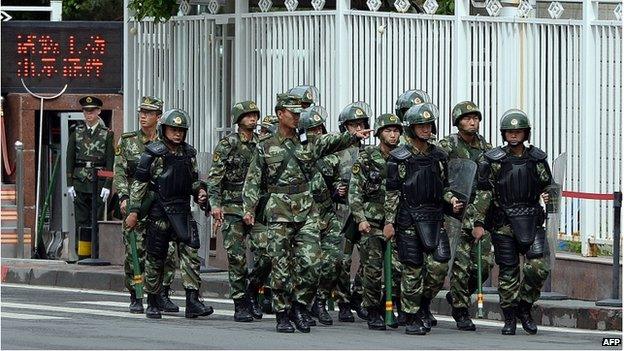 This file picture taken on on 23 May 2014 shows fully armed Chinese paramilitary police patrol a street in Urumqi, the capital of farwest China's Muslim Uighur homeland of Xinjiang.