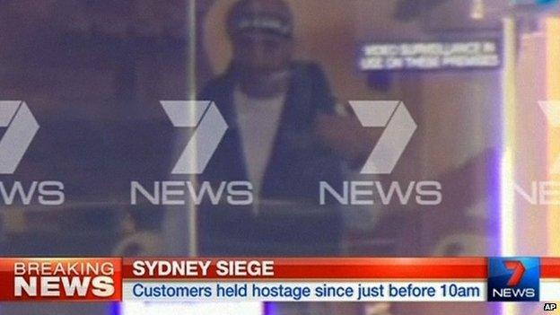 This image taken from video shows a man believed to be the gunman, Man Haron Monis, inside a cafe in Sydney, Australia Monday, Dec. 15, 2014.