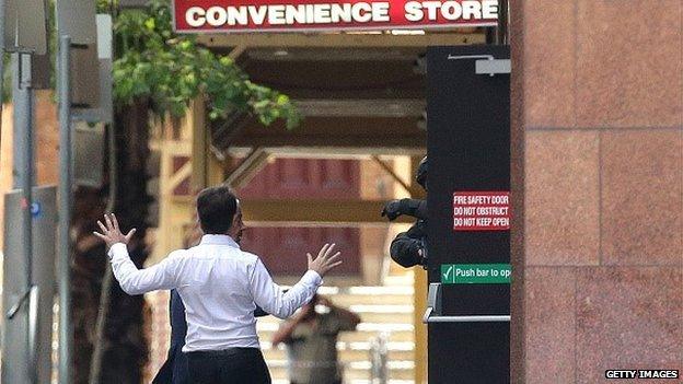 Two hostages run to safety outside the Lindt Cafe, Martin Place on December 15, 2014 in Sydney, Australia