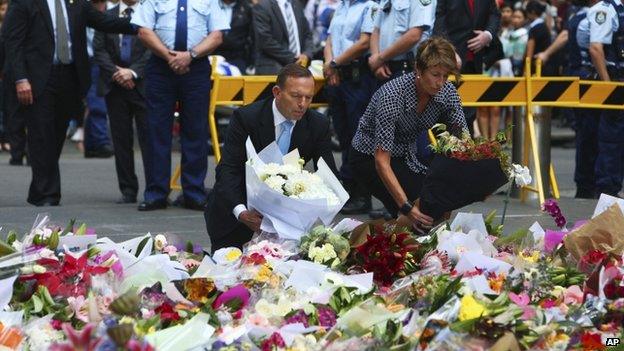 Australian Prime Minister Tony Abbott and his wife Margie pay their respect to the victims of the siege in Martin Place in Sydney central business district, Australia. Tuesday, 16 December 2014