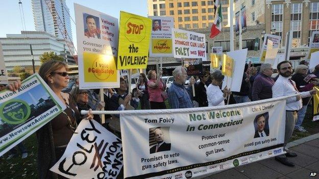 Members of various gun control groups protest New Jersey Gov. Chris Christie"s visit to Stamford while he stumps for Connecticut gubernatorial candidate Tom Foley across the street from a fundraiser at Bobby V's Sports Bar, in Stamford, Connecticut, on Tuesday, 23 September 2014