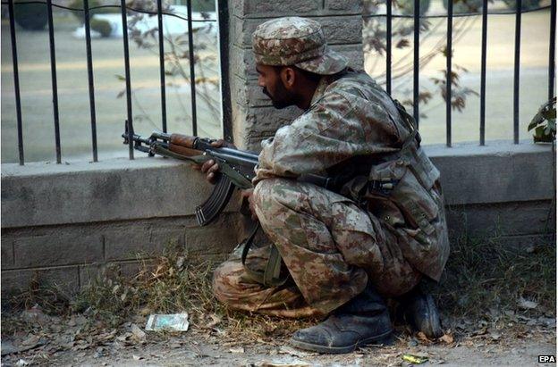 A Pakistani soldier takes position following an attack at the army run school, in Peshawar Pakistan, 16 December 2014