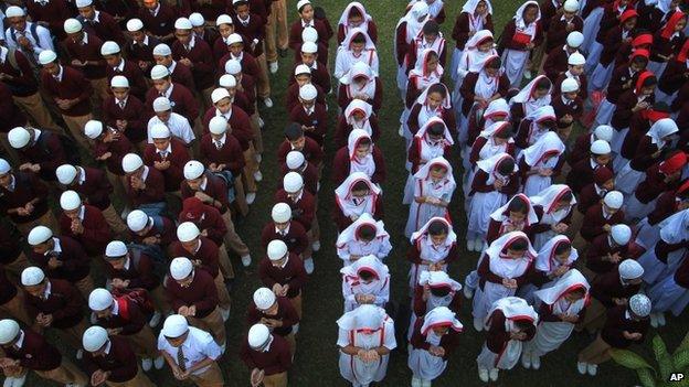 Pakistani students attend a praying ceremony for the victims of Tuesday's school attack, at a school in Karachi, Pakistan, on 17 December 2014.