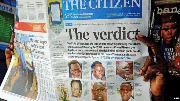 A newspaper vendor holds a copy of The Citizen newspaper in Dar es Salaam, Tanzania on 27 November 2014