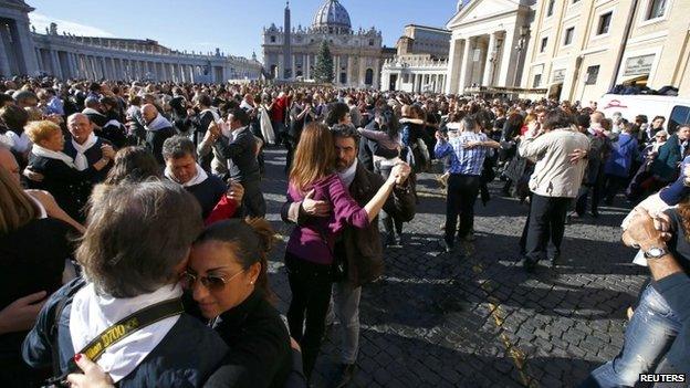 Couples dance in front of Saint Peter"s basilica at the Vatican December 17, 2014