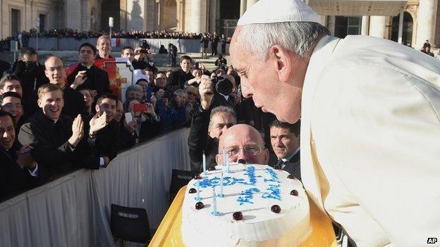 In this photo provided by Vatican newspaper L"Osservatore Romano, Pope Francis blows candles on a cake during his weekly general audience in St. Peter"s Square at the Vatican, Wednesday, Dec. 17, 2014