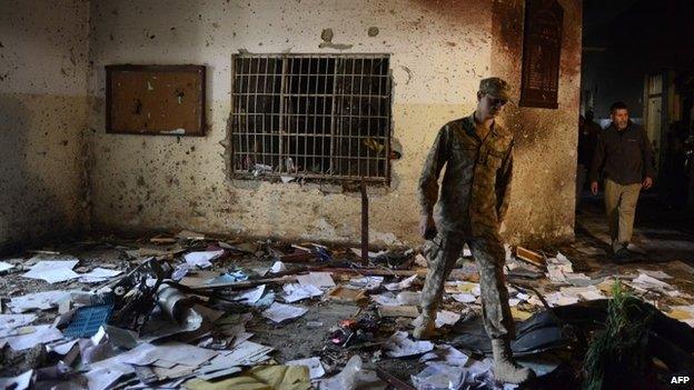 A Pakistani soldier walks amidst the debris in an army-run school a day after an attack by Taliban militants in Peshawar - 17 December 2014