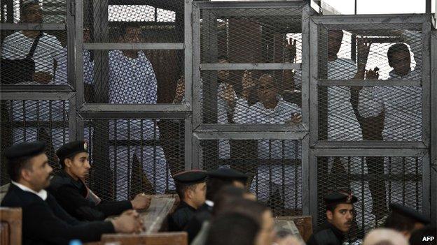 Peter Greste, Mohammed Fadel Fahmy and Baher Mohammed in a cage in court, Cairo (March 2014)