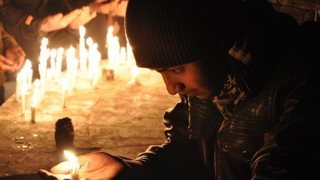 Pakistani mourner lights a candle to pray for the victims who were killed in an attack at the Army run school in Peshawar