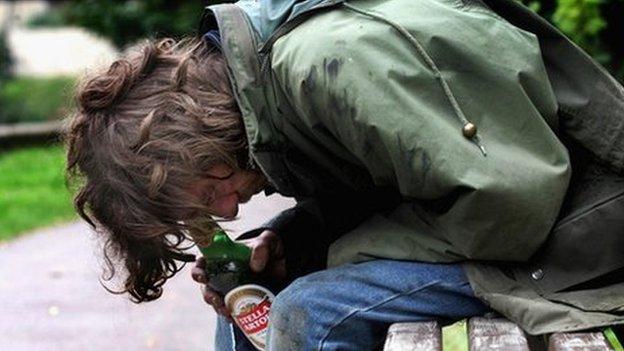 Person with drink on a park bench