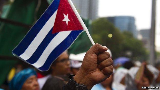 A man raises his fist with a Cuban flag in Mexico City on 26 July 2011