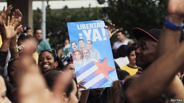 People cheer for the "Cuban Five" while holding a poster of the five Cuban intelligent agents, in Havana 17 December 2014.