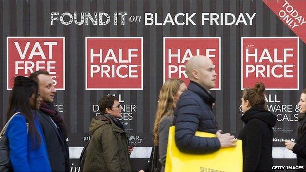 Shoppers in front of Black Friday sign