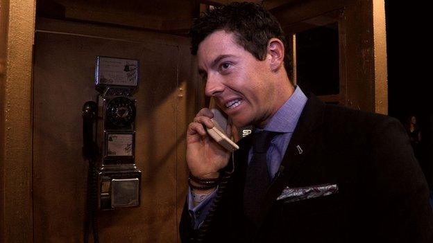 Rory McIlroy on a phone in a phone box