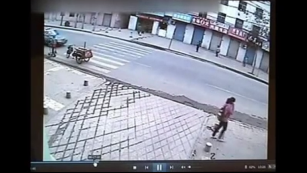 A few minutes after this picture was taken, the woman walking down the street in China fell into a sinkhole as it opened up. She did survive.