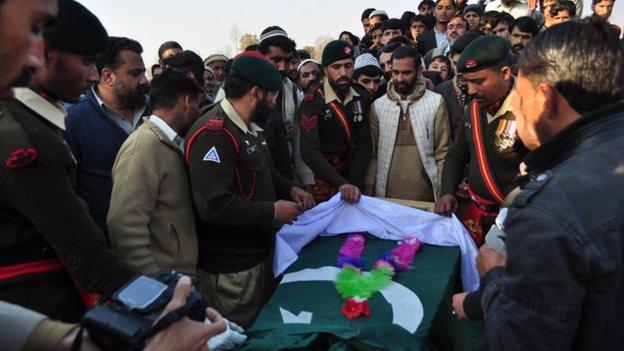 Pakistani army personnel gather around the coffin of army soldier who was killed in the school attack, during a funeral in Mansehra on December 17, 2014.