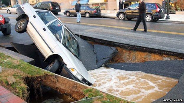 A car falls into a sinkhole caused by a burst water main in Chevy Chase, Washington DC