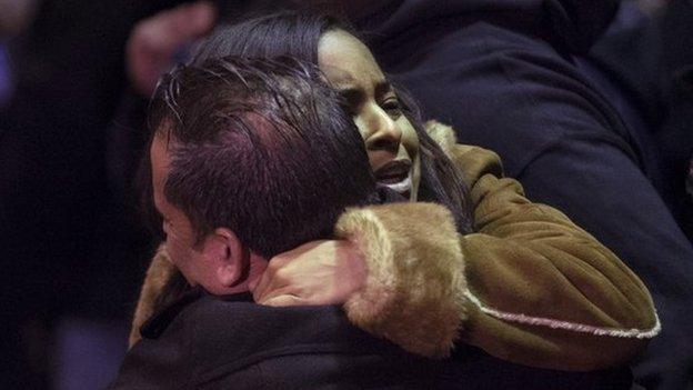 Mourners gather before the bodies of two NYPD police officers are transported to a hospital, 20 December