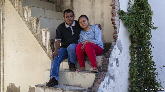 Tsunami survivors Mustafa and Rina sit together on the steps of a house