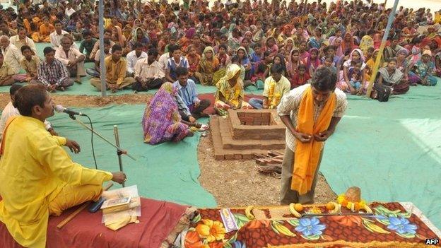 An Indian tribesperson (R, foreground) participates in a conversion ritual of some 200 Christians into Hinduism, at Aranai Village in Valsad district of Gujarat state, some 350 kms from Ahmedabad, on December 20, 2014.