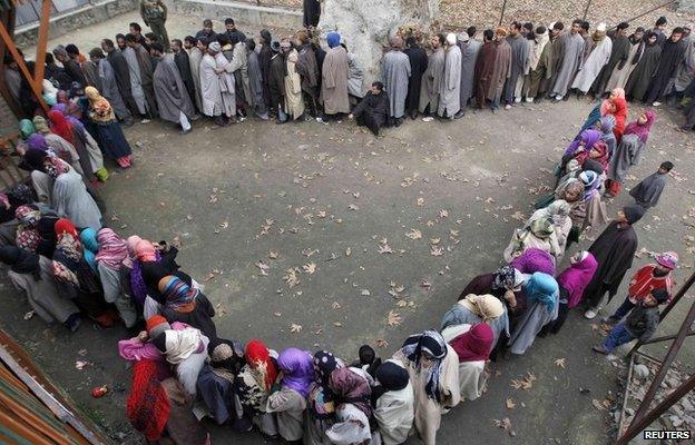 Kashmiri people wait in queues outside a polling station to cast their votes during the fourth phase of the state assembly election in Srinagar December 14, 2014.