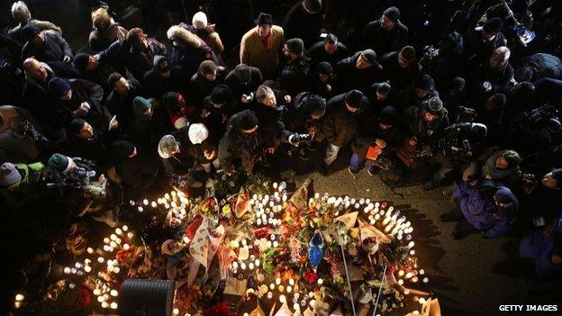 Residents, clergy, police and others converge around a memorial during a vigil to the fallen New York City police officers at the location where they were killed 21 December 2014