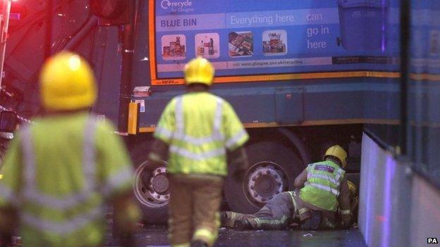 Firefighters looking under the lorry