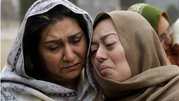 Grief-stricken family members of students killed in a Taliban attacked comfort each other during a gathering at the Army Public School in Peshawar, Pakistan, Monday, Dec. 22, 23014