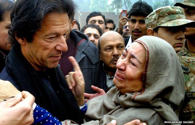 Imran Khan, left, Pakistan's cricketer-turned politician comforts a family member of a student killed in a Taliban attack in Peshawar, Pakistan, Monday, Dec. 22, 23014