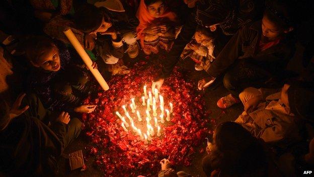 Pakistani children gather around lit candles for the victims of an attack by Taliban gunmen on an army-run school in Peshawar, in Karachi on December 17, 2014