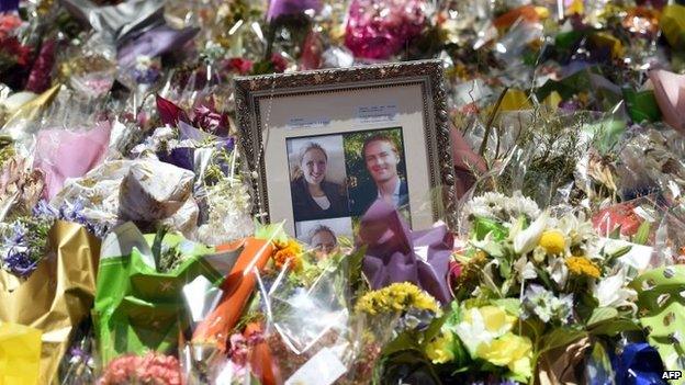 Photos of Katrina Dawson (left) and Tori Johnson (right) amongst floral tributes left outside the Lindt Cafe in Sydney's Martin Place (22 December 2014)