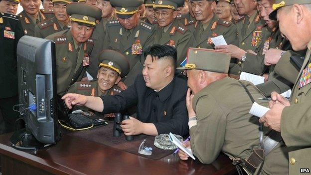 An undated handout picture released by the North Korean Central News Agency (KCNA) on 27 April 2014 shows North Korean leader Kim Jong-un (C) looking at a computer screen along with soldiers of a long-range artillery unit at an undisclosed location in North Korea.