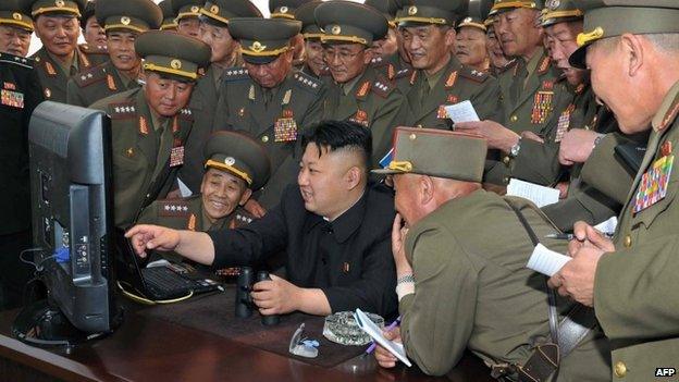 North Korean leader Kim Jong-un looks at a computer, surrounded by army chiefs - 27 April 2014