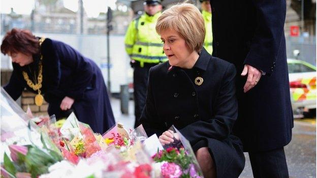 Lord Provost Sadie Docherty and First Minister of Scotland Nicola Sturgeon look at flowers left near to the scene of yesterday's bin lorry crash