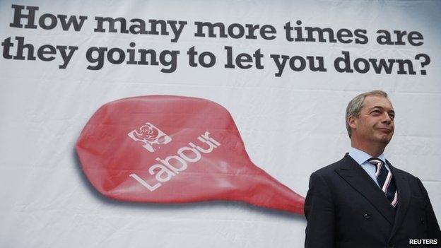 UKIP leader Nigel Farage standing highlights a campaign poster during October's Heywood and Middleton by-election